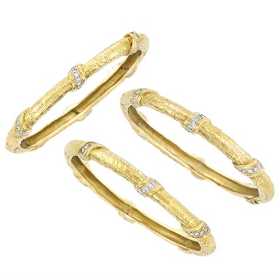 Lot 453 - Three Hammered Gold, Platinum and Diamond Bangle Bracelets
