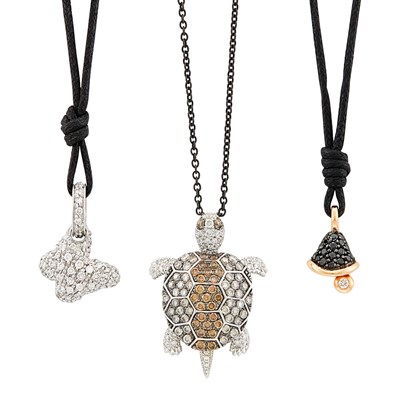 Lot 259 - Three Tricolor Gold, Diamond, Colored Diamond Turtle, Butterfly and Bell Charms with Blackened Gold and Cord Necklaces