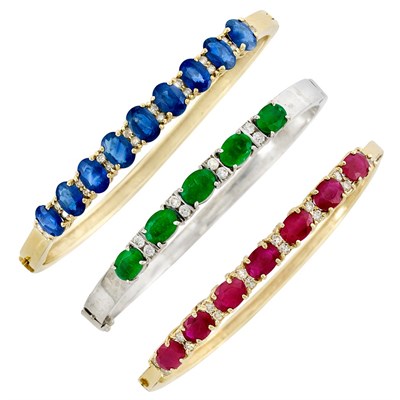 Lot 116 - Three Two-Color Gold Diamond, Sapphire, Emerald and Ruby Bangle Bracelets