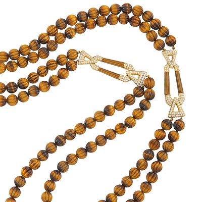 Lot 368 - Double Strand Carved Tiger's Eye Bead, Gold and Diamond Necklace