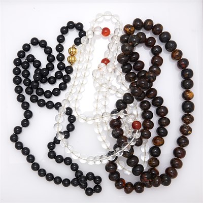Lot 1812 - Three Rock Crystal, Carnelian, Black Onyx and Amber Bead Necklaces