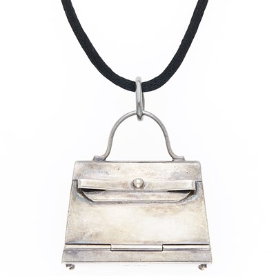 Lot 1039 - Hermès Silver 'Kelly' Bag Pendant with Cord Necklace, France