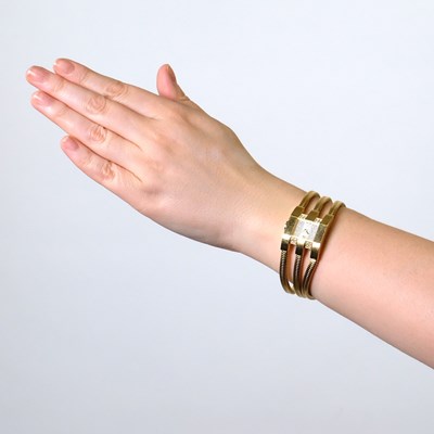 Lot 33 - Van Cleef & Arpels Triple Strand Gold, Mother-of-Pearl and Diamond 'Liane' Snake Chain Wristwatch