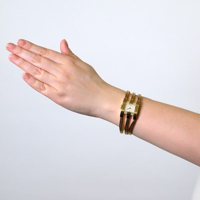 Lot 33 - Van Cleef & Arpels Triple Strand Gold, Mother-of-Pearl and Diamond 'Liane' Snake Chain Wristwatch