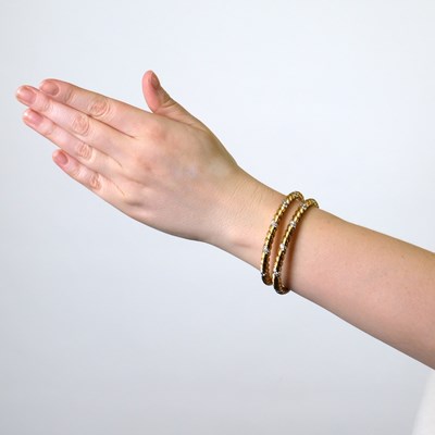 Lot 77 - Georges L'Enfant for Van Cleef & Arpels Pair of Fluted Gold, Platinum and Diamond Bangle Bracelets, France