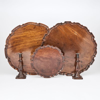 Lot 202 - Three Georgian Mahogany Pie Crust Trays Together with a Pair of Victorian Mahogany Candlesticks