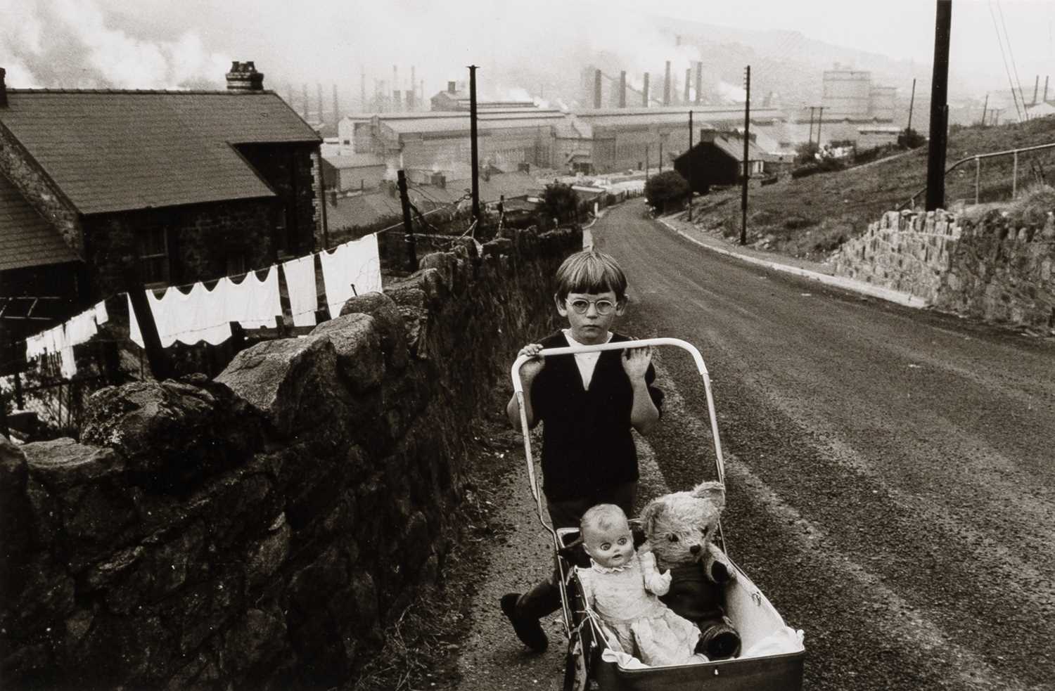 Lot 33 - Bruce Davidson, Child in glasses pushing stroller with doll and teddy bear], 1965