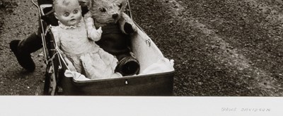 Lot 33 - Bruce Davidson, Child in glasses pushing stroller with doll and teddy bear], 1965