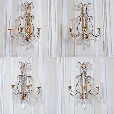 Lot 573 - Set of Four Neoclassical Crystal, Gilt Metal, Gilt Wood and Mirrored Three-Light Wall Sconces