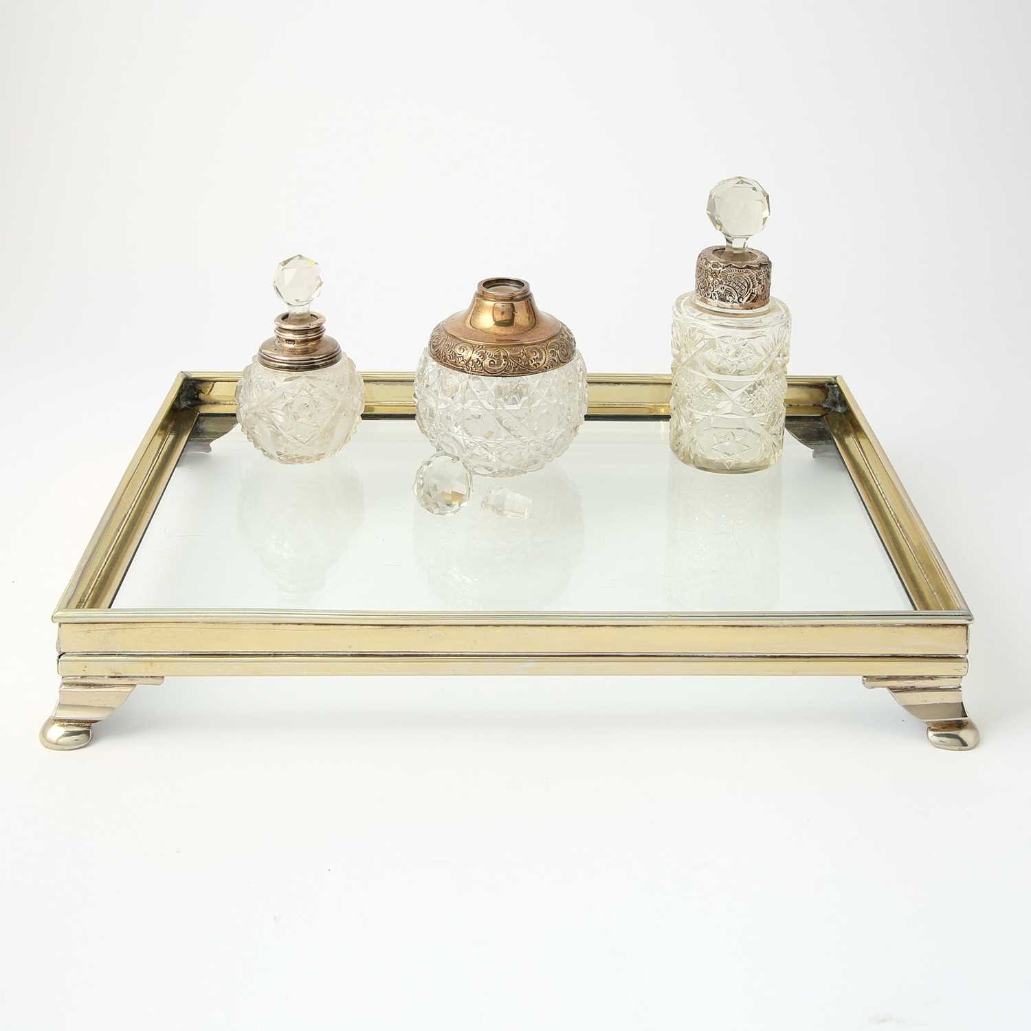 Lot 112 - Three Silver-Mounted Cut-Glass Stoppered Perfume Bottles on a Silver-Plated Glass-Bottom Tray