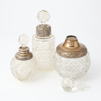Lot 112 - Three Silver-Mounted Cut-Glass Stoppered Perfume Bottles on a Silver-Plated Glass-Bottom Tray