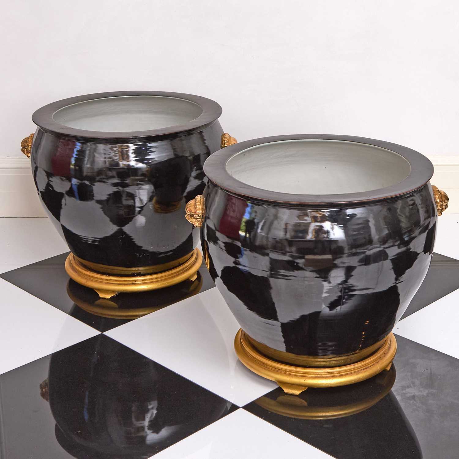 Lot 141 - Large Pair of Chinese Black Glazed Porcelain Planters with Gilt Lion's Masks on Giltwood Stands