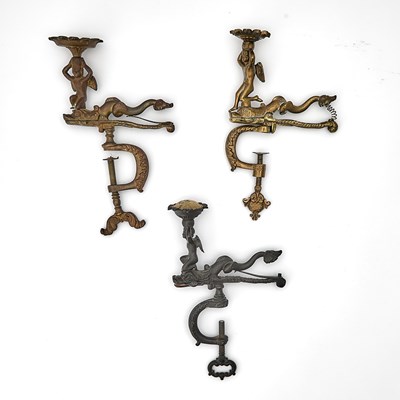 Lot 279 - Three Cast Sewing Clamps with Dolphins and Seated Cupi