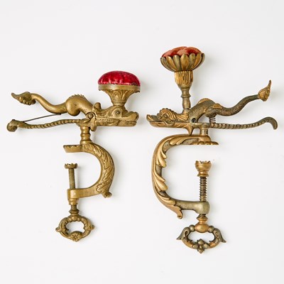 Lot 1248 - Two Cast Brass Dolphin / Serpent Figural Sewing Clamps with Pin Cushions