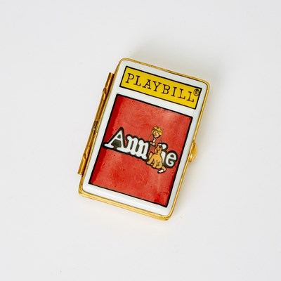 Lot 30 - A porcelain box in the shape of an Annie playbill