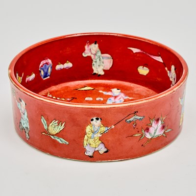 Lot 242 - A Chinese Enameled Red Ground Porcelain ‘Boys’ Bowl