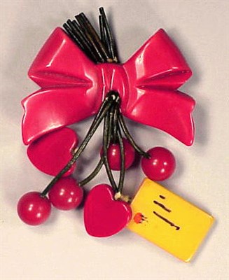 Lot 442 - Bakelite Brooch Featuring a red ribbon...