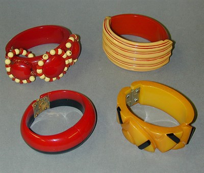Lot 604 - Group of Four Bakelite Hinged Bracelets Each...