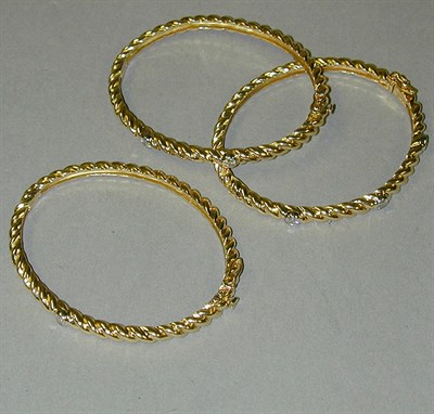 Lot 378 - Three Gold and Diamond Bangle Bracelets 18 kt....