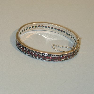 Lot 190 - Garnet Bangle Bracelet The rigid metal...