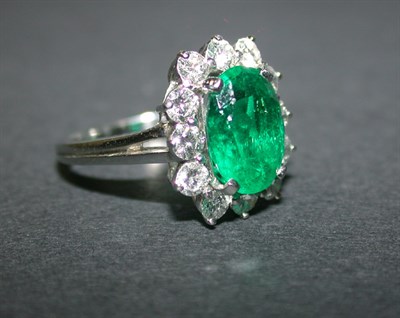 Lot 425 - Emerald and diamond cluster ring, platinum,...