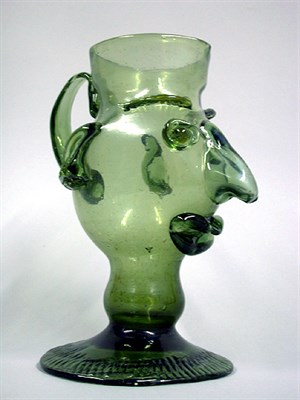 Lot 102 - Glass Figural Pitcher Depicting a hooked nose...