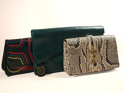 Lot 702 - Three Leather Clutches The first a bottle...