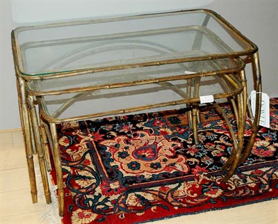 Lot 483 - Gilt-Metal and Glass Nest of Three Tables...