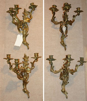 Lot 1246 - Set of Four Rococo Style Brass Three-Light...
