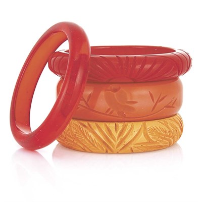 Lot 26 - One Celluloid and Three Carved Bakelite Bangle Bracelets